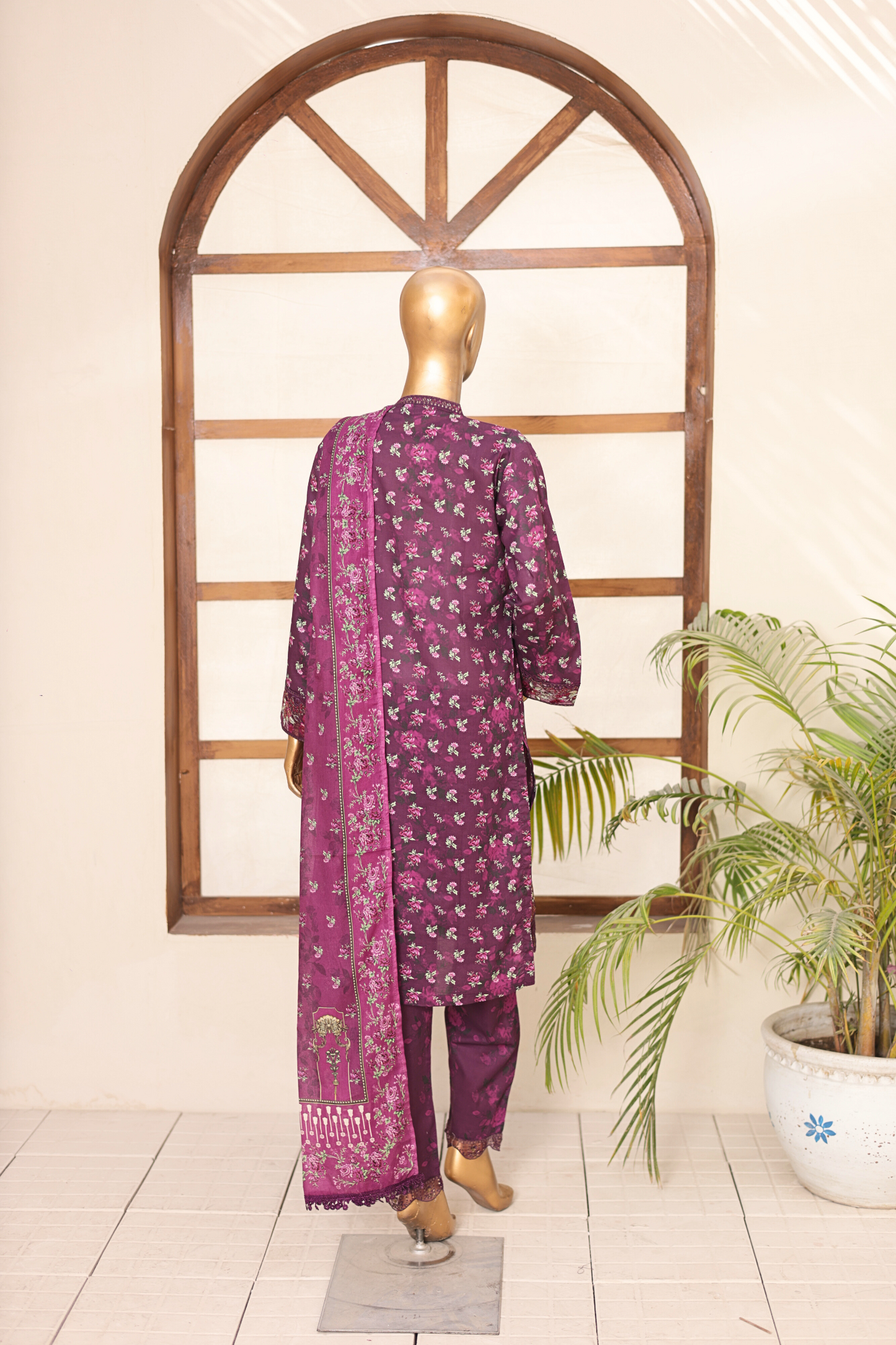 Mannequin wearing a purple traditional outfit with a floral pattern in front of a decorative archway.