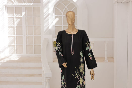 Black dress with floral embroidery on a mannequin in a bright room.