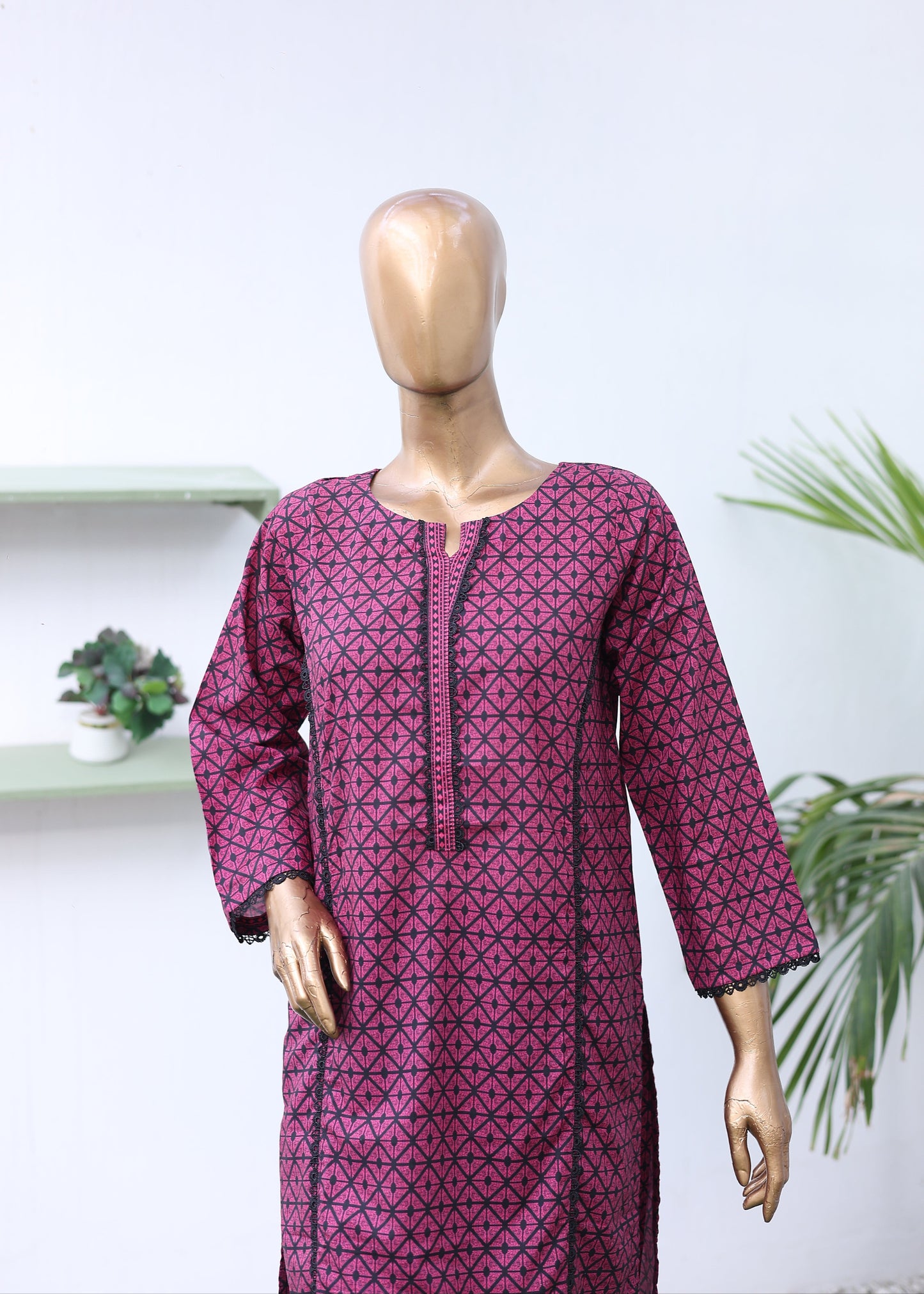 Mannequin wearing a patterned pink outfit with a white background