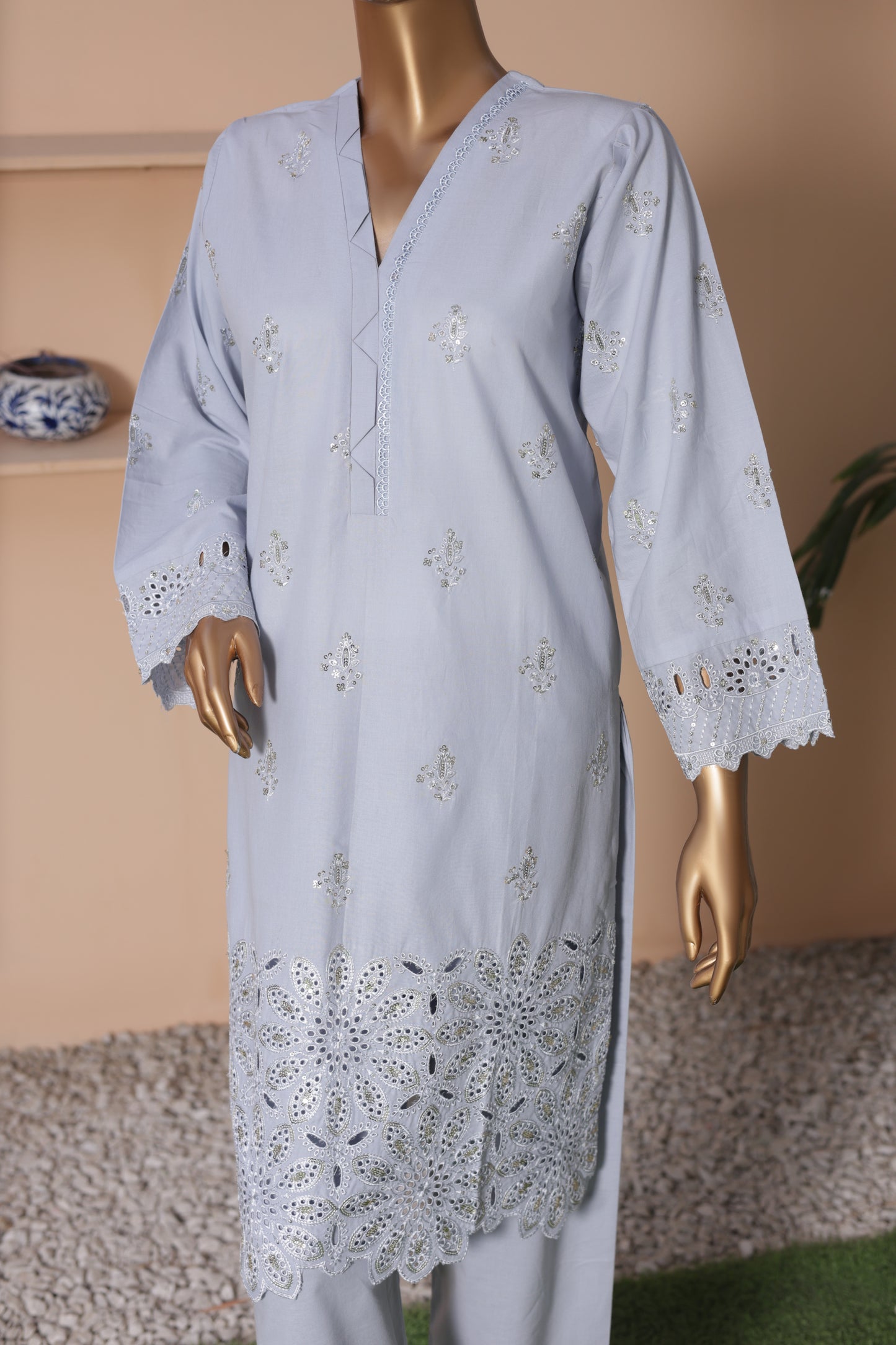 Light blue embroidered dress on a mannequin against a neutral background