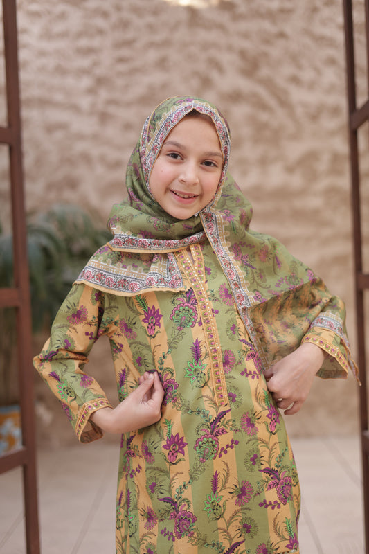 Child wearing a green and yellow traditional outfit with a matching headscarf.