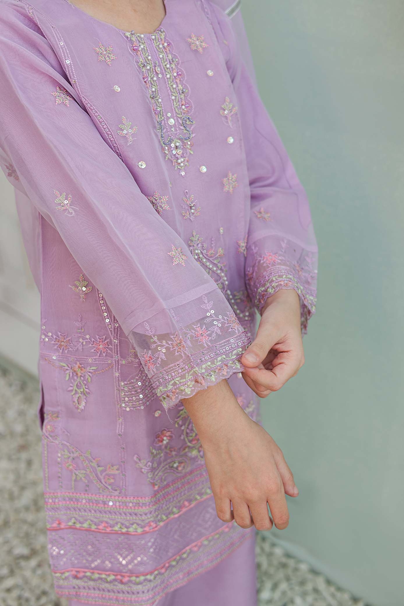 Lavender embroidered outfit with a blurred background