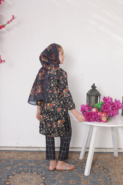 Person wearing a floral dress and headscarf sitting on a chair with flowers and a lantern on a white surface.