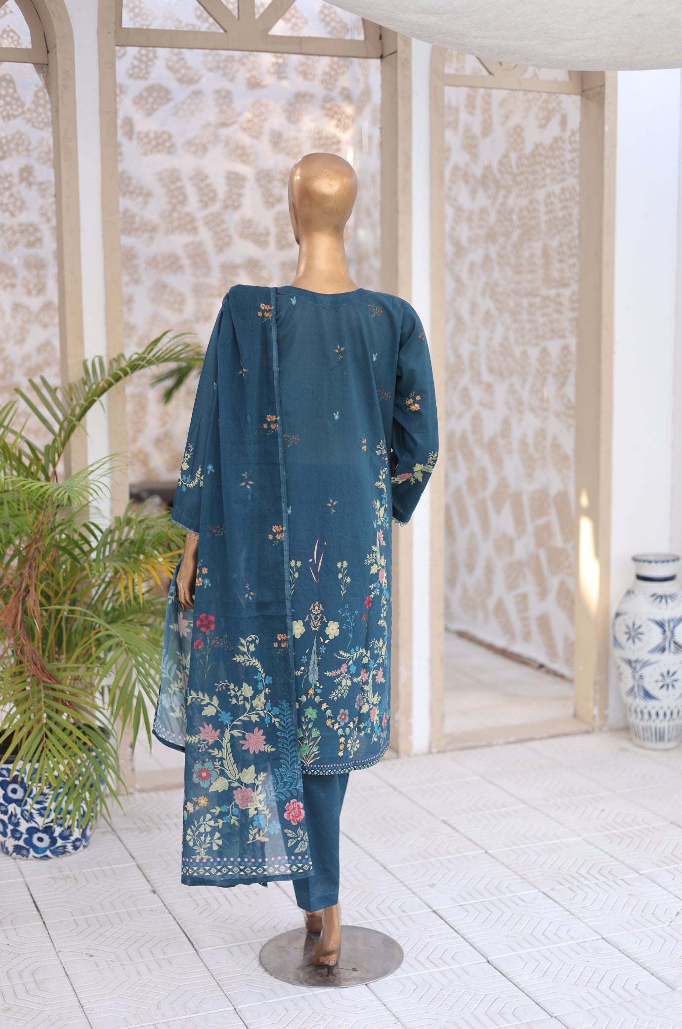 Mannequin wearing a blue floral dress in a room with decorative elements.