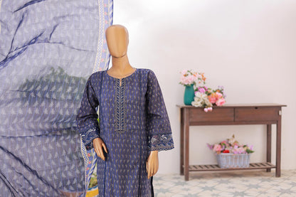 Mannequin wearing a blue patterned dress with a large fabric swatch and flowers in the background.