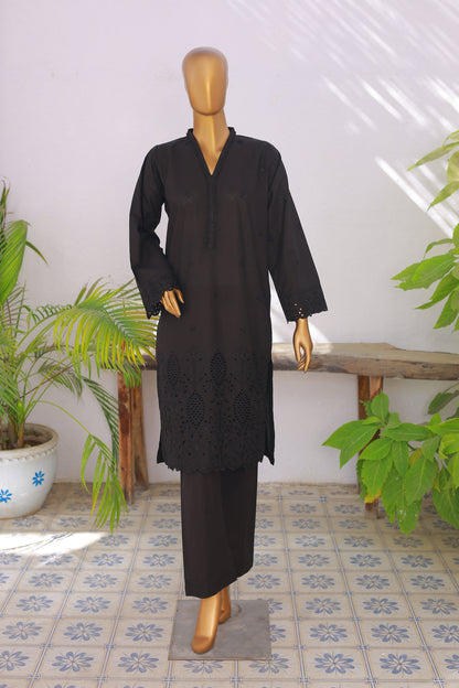Mannequin wearing a black outfit with a white wall and plants in the background