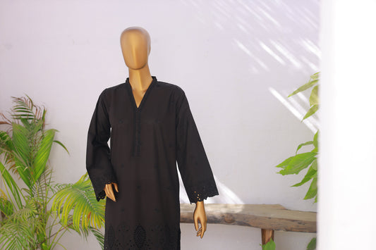 Black dress on a mannequin against a white background with plants.