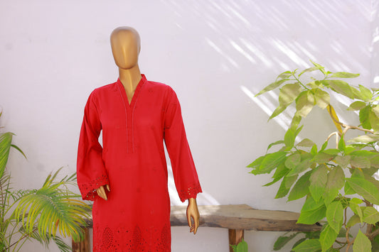 Red dress on a mannequin with plants in the background