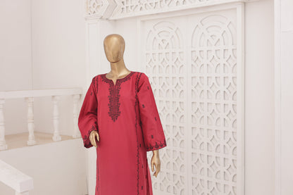 Red dress with black embroidery on a mannequin against a white decorative wall.