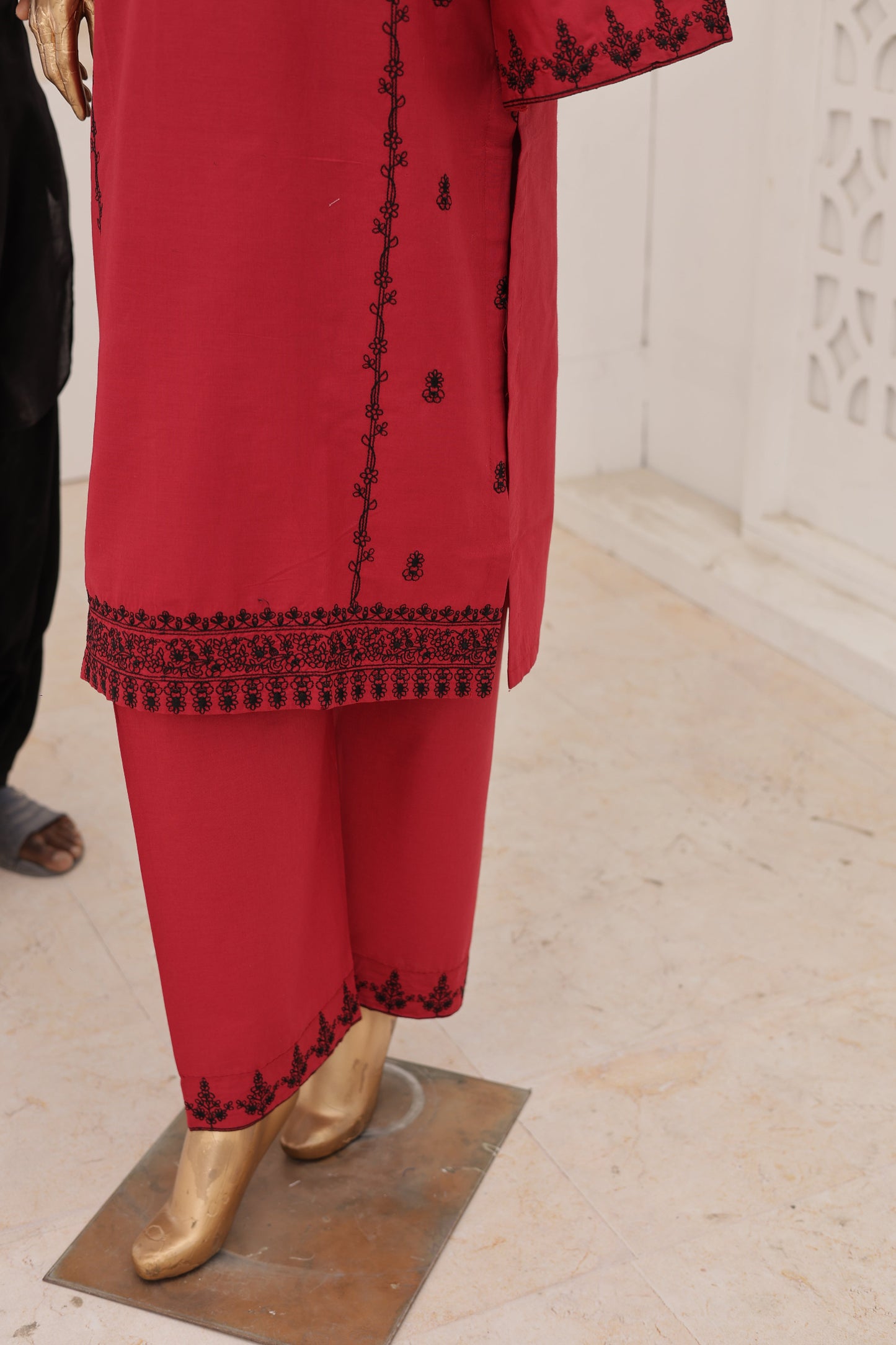 Red outfit with black embroidery on a white background