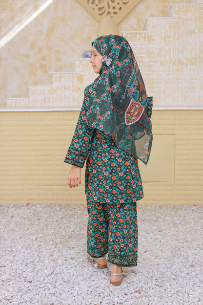 Woman wearing a floral outfit with a matching headscarf in an outdoor setting.