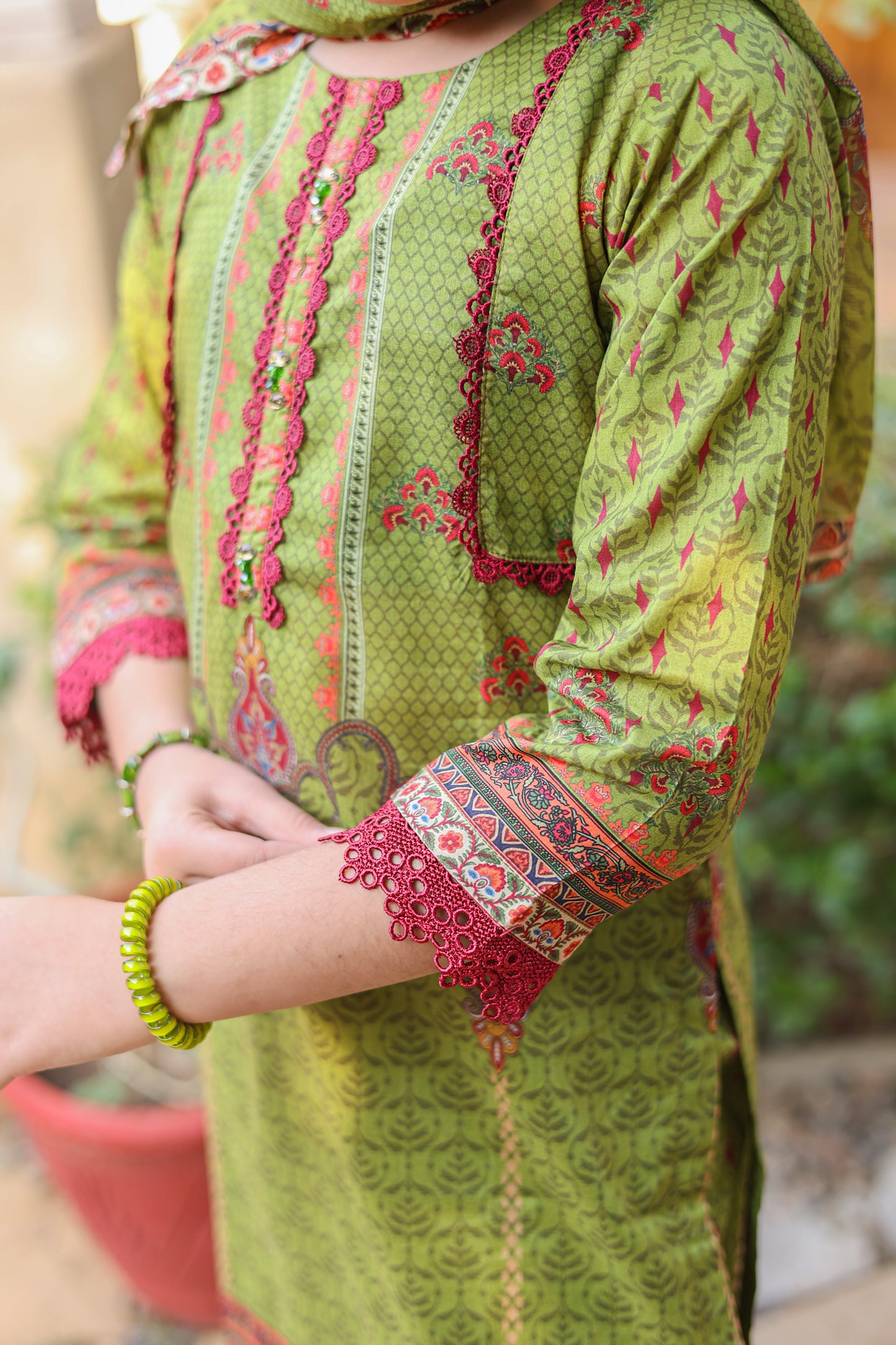 Green embroidered traditional outfit with red and multicolor patterns