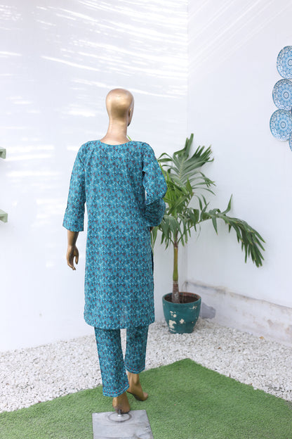 Mannequin wearing a blue patterned outfit with a potted plant on a white background