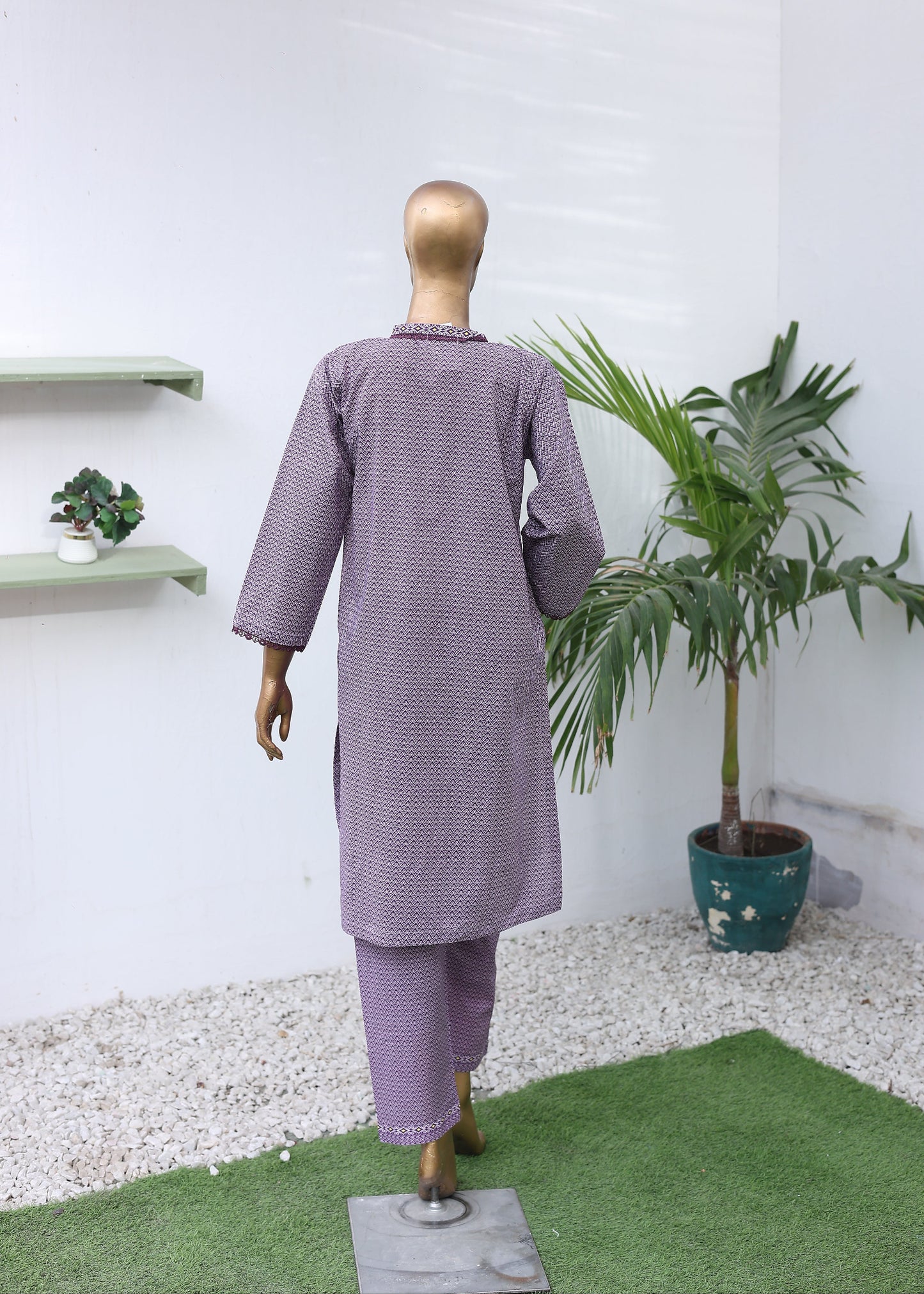 Mannequin wearing a purple outfit with a white background and plants.