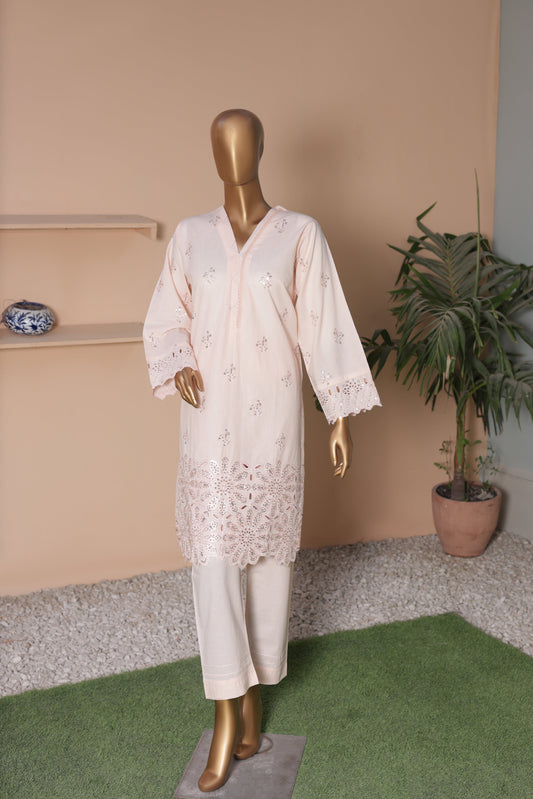 Mannequin wearing a white lace outfit in a room with a plant and shelf.