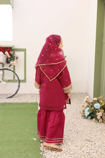 Person wearing a red outfit with gold trim standing on a green and white surface.