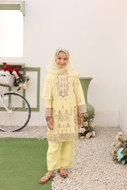 Woman in a yellow dress with floral patterns standing on a white surface with green background
