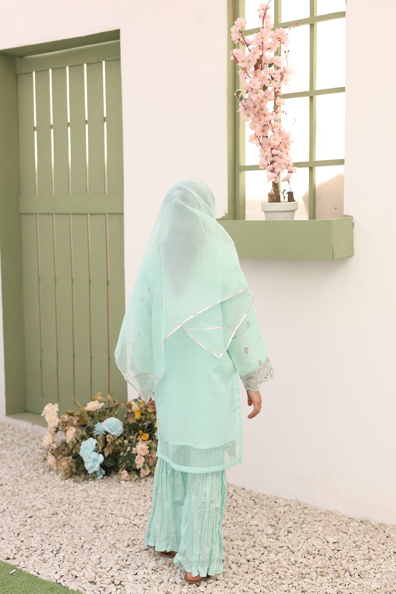 Light blue dress with floral decorations on a neutral background