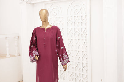 Maroon dress with white patterns on a mannequin against a decorative white wall.
