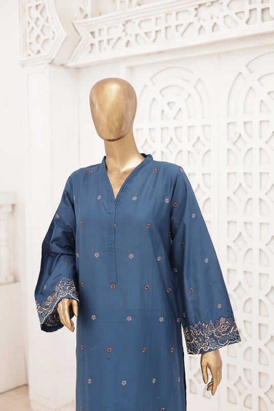 Blue dress with floral embroidery on a mannequin against a decorative white wall.
