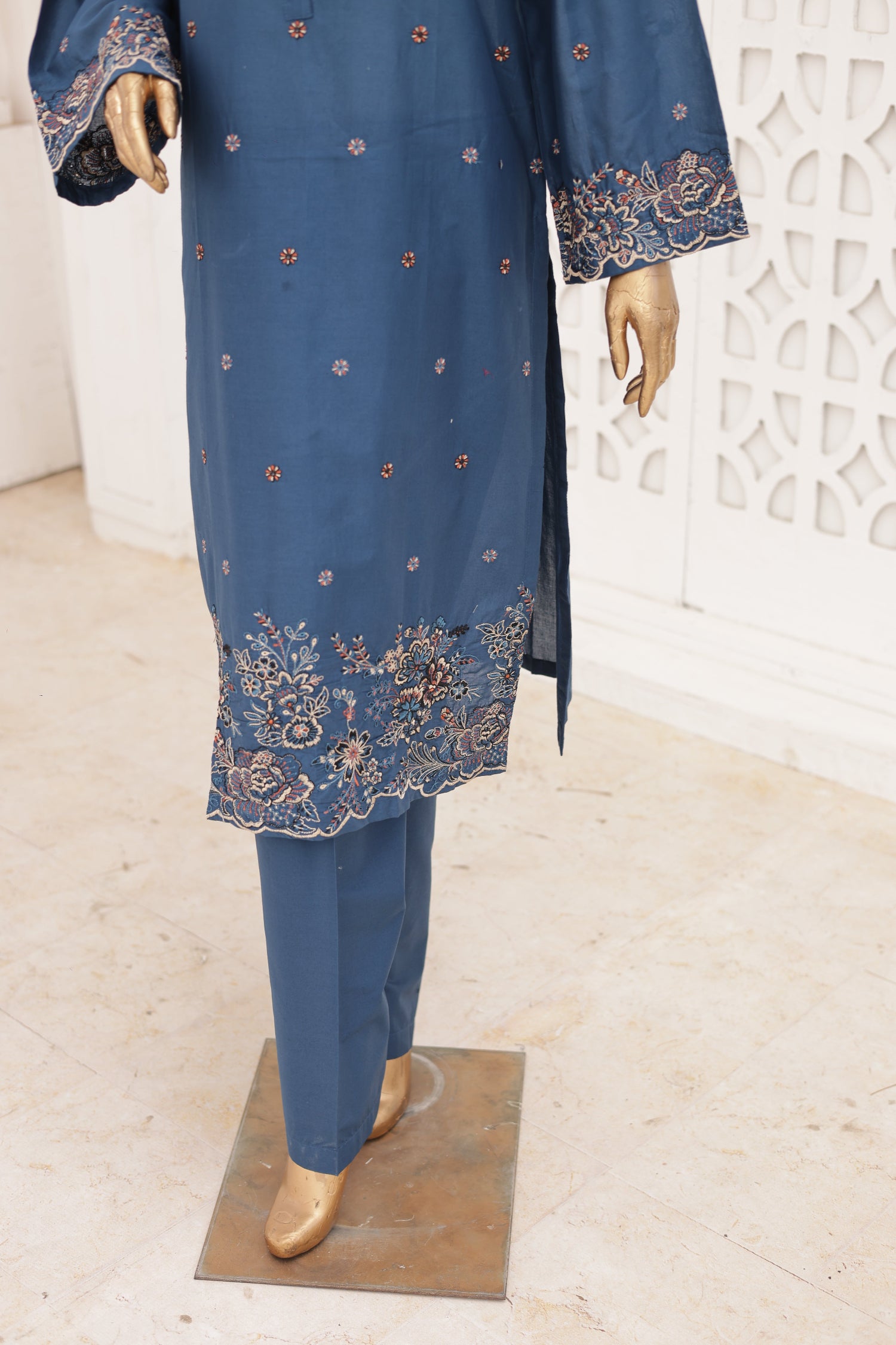 Blue embroidered outfit on a mannequin against a white wall.