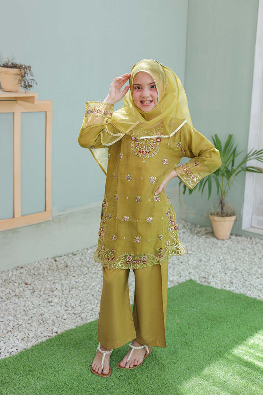 Woman wearing a yellow traditional outfit with a matching headscarf indoors.